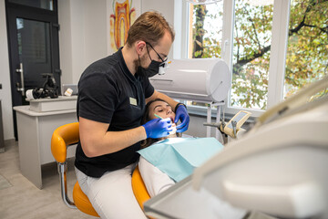 dentist examines a patient's teeth in a modern dental office. Close up.