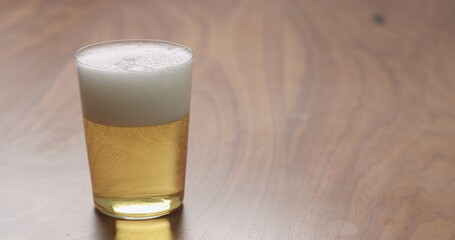 Slow motion apple cider in thin glass on wood surface with copy space