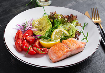 Ketogenic diet breakfast. Baked salmon salad with greens, tomatoes, red onions and avocado. Keto, paleo lunch.