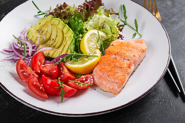 Ketogenic diet breakfast. Baked salmon salad with greens, tomatoes, red onions and avocado. Keto, paleo lunch.