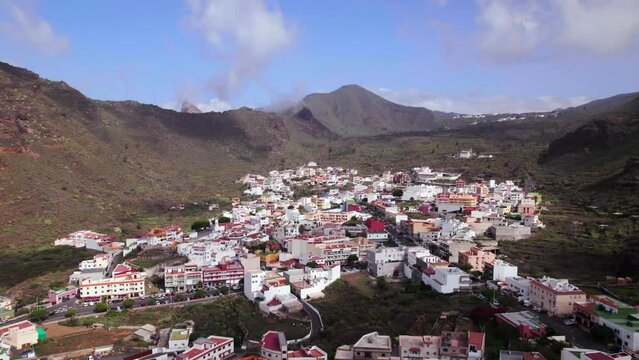 Aerial orbit view of Tamaimo town in a green mountain valley, Tenerife