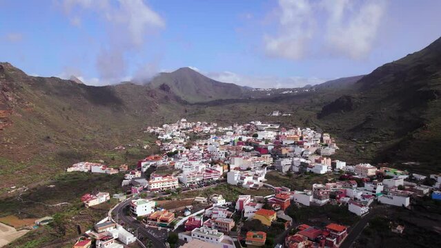 Aerial reveal view of the city Tamaimo in a greenery mountain valley