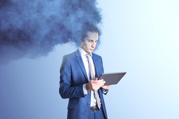 Head in the clouds concept. Cloud head attractive european businessman using tablet on light background. Work trouble.
