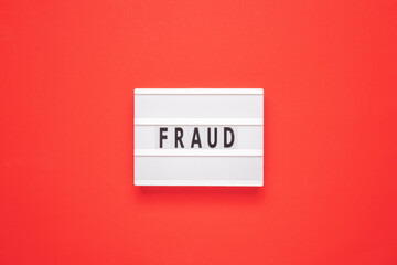 Lightbox with word fraud on red background. Business concept.