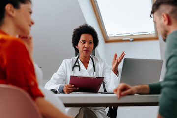 Obstetrician advising young parents to be.