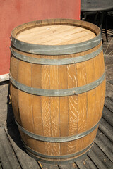 Fototapeta premium A large wooden barrel stands on the street near the building as a facade decoration.