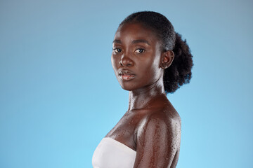 Face, beauty and skincare with a model black woman wet in studio on a blie background with mockup....