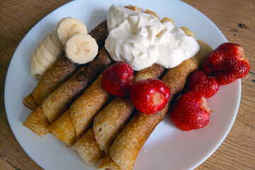 Delicious light breakfast. Pancakes with sour cream and fruit.
