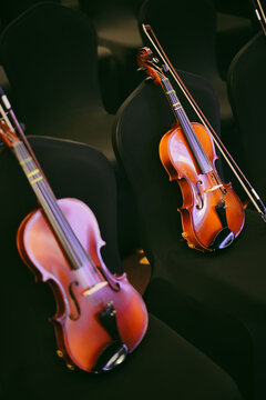 Two violins on some chairs