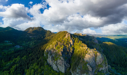 Peak of Rhodope mountain with forests against background of clouds. Panorama, top view