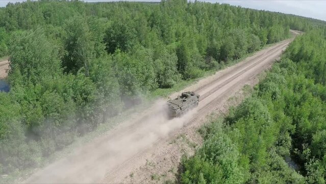 flying over the military vehicle driving in rough wooded country
