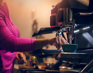 Barista is making coffee with the machine in vintage tones.