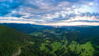 Valley of Balkan mountains with fog, sunny clouds and forests. Village Pamporovo. Panorama, top view