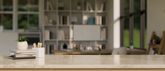 Natural marble tabletop with books, stationery, decor plant and copy space over blurred modern office workspace
