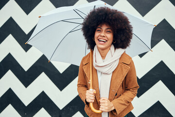 Creative, fashion and black woman with umbrella in city standing by black and white pattern wall....