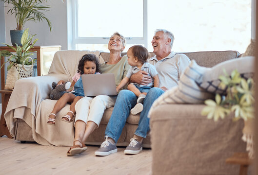 Happy, family and laptop on the sofa with children and grandparents on home sofa. Senior man and woman relax online with their adopted grandchildren while watching funny movie, streaming or cartoon