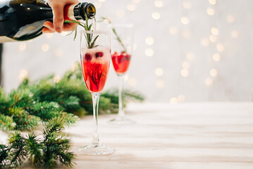 Hands preparing mimosa christmas festive red drink with sparkling wine