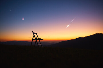 Chair in nature under the evening sky with Moon, stars, planets and meteor shower.