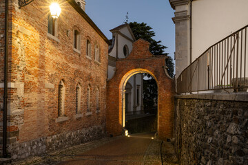 Narrow Italian cobblestone alley at dusk.
