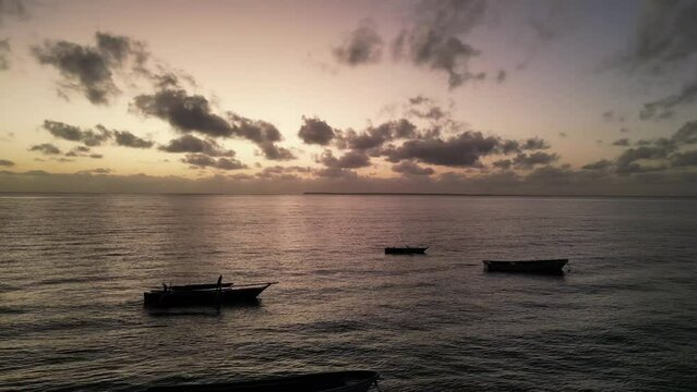 Fishing boats anchored at Uroa beach coast in Zanzibar Island during sunset, Tanzania Africa during sunset, Aerial dolly right shot