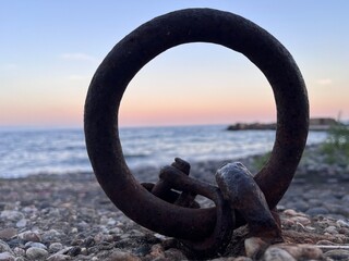 Obraz premium Anello di ferro arrugginito, incementato a terra sul molo per ormeggiare le barche