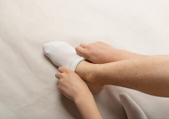 Boy Puts on Sock, Man Putting Socks or Take It off