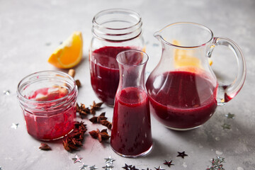 Homemade jars and bowls with cranberry sauce. Star Anis and oranges are shown in the background