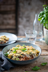 Creamy zucchini pasta with cheese. Glass of water in the background
