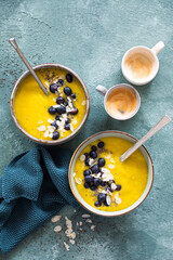 Turmeric smoothie with blue berries and coconut flakes