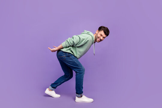 Full size photo of handsome young man carry back heavy object stressed wear trendy gray isolated on violet color background