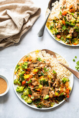 Vegetarian stir fry with rice and vegetables on a table with two plates