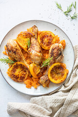Delicious plate filled with sweet potato and roasted chicken drumsticks with caramelized oranges