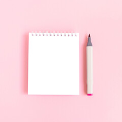 Clean notepad mockup and felt tip pen on a pink pastel background. Empty notebook template.
