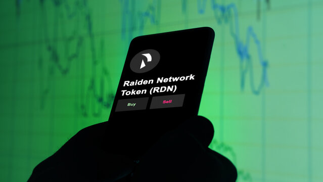 November 3th 2022, Berlin. An investor's analyzing the Raiden Network Token token 'RDN' coin on screen. A phone shows the crypto's prices to invest