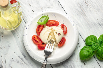 fresh soft white burrata cheese ball made from mozzarella and cream from Apulia, Italian Mediterranean cuisine, Food recipe background. Close up