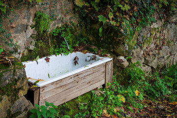 Uriage les Bains France 11 2022 original fountain in the middle of nature made with an old recycled bathtub