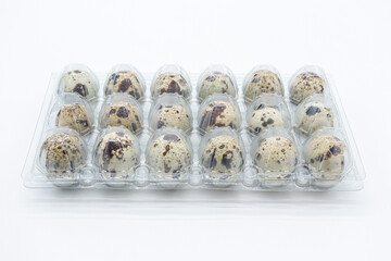 quail eggs packed in a plastic box on a white background