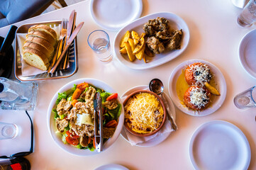 Family eating traditional Greek food in restaurant tavern in Greece.
