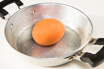 Old aluminum pan seen from above with an egg in the middle
