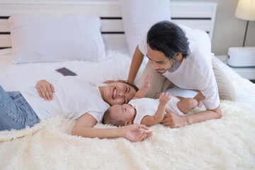 Mom and father happy joyful teasing asian infant baby new born have fun looking to parent face
