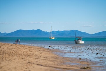 white sand beach in queensland Australia with boats and tourism