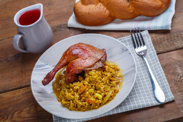 Amber boiled spelled with duck leg baked in a plate on a napkin with a fork.