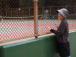 テニスを笑顔で観戦する高齢日本人女性