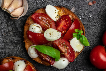 Open sandwiches with cherry tomatoes, mini mozzarella, fresh basil leaves, caprese on bread, Traditional italian appetizer or snack, antipasto. banner, menu, recipe place for text, top view