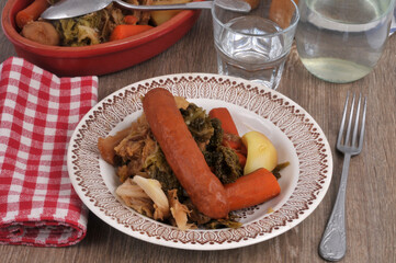 Potée au chou servie dans une assiette avec un verre