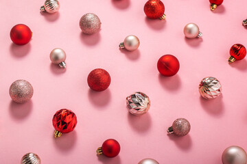 Pink and red decorative balls on a pink background. Top view, flat lay.