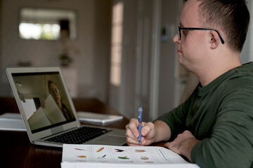 Caucasian man with down syndrome having lesson online