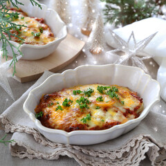 Homemade gratin with potato, meet  and cheese in baking dishes on Christmas decoration table. ポテトのミートグラタン ポテトグラタン