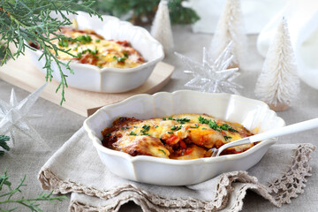 Homemade gratin with potato, meet  and cheese in baking dishes on Christmas decoration table. ポテトのミートグラタン ポテトグラタン