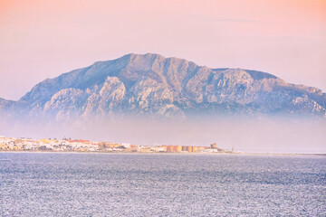 musa mountain in tarifa sea with fog and sunrise colors calm sea beautiful landscape